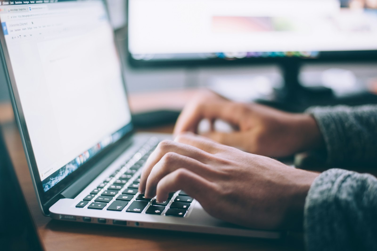 Hands working at a laptop